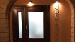 A hotel entrance with a dark wooden door, a frosted glass panel, and a sign reading "MONTEMARE". - B&B Montemare (Agrigento)