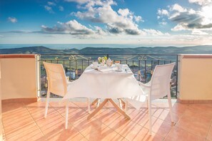 A terrace with a table set for two, overlooking a scenic landscape. - B&B Montemare (Agrigento)