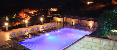 Una piscina al aire libre de temporada, sillones reclinables de piscina