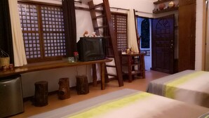 A room with two beds, a desk with a television, wooden stools, and a ladder. - Wonderfarm Villa (Calatagan)