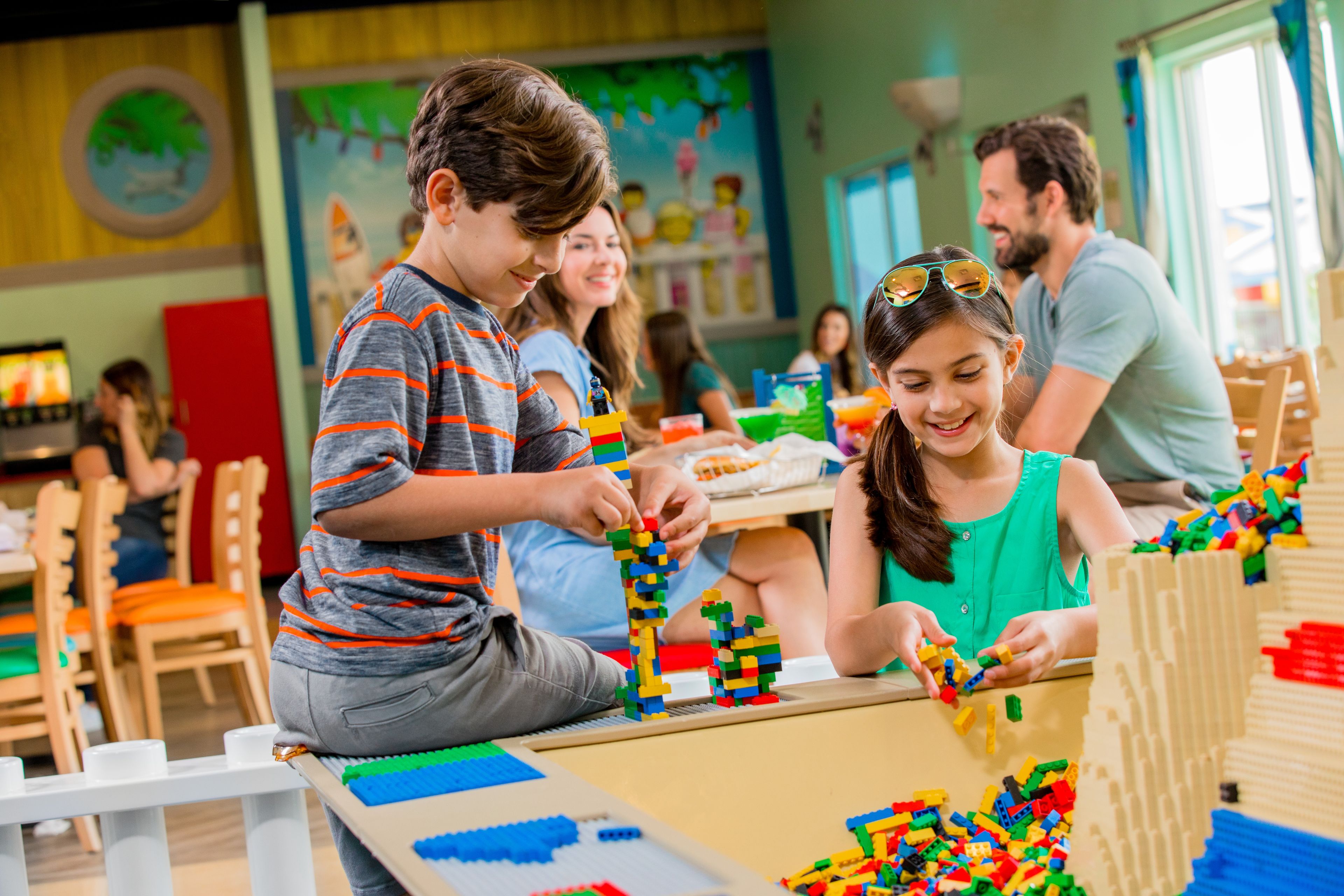 Children playing with building blocks in a classroom setting.