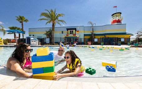 A swimming pool area with people playing with building blocks.