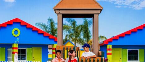 A colorful building with a play structure in front.