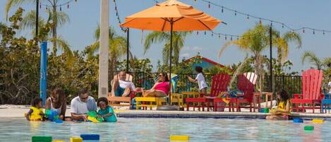 Alberca al aire libre, sombrillas en la alberca y camastros