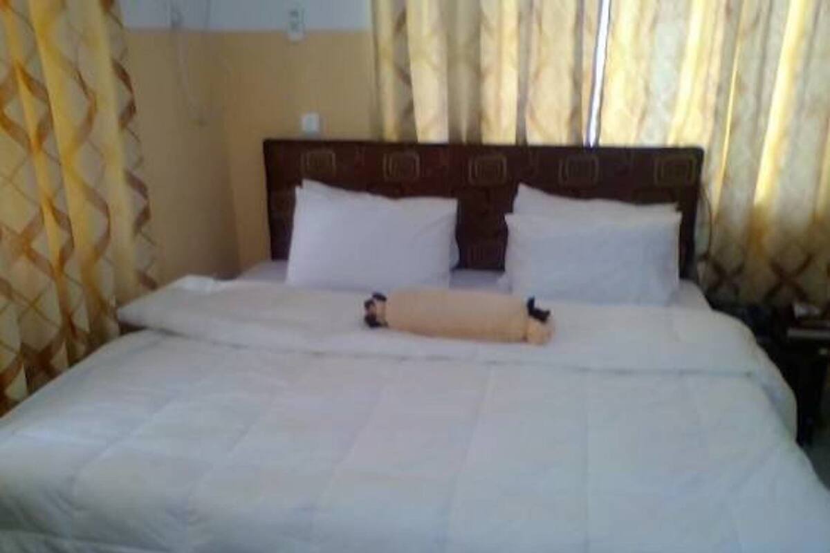 A bed with white bedding and a wooden headboard.