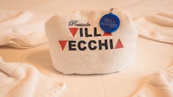 Una toalla con el texto 'Pousada Villavecchia' y una etiqueta azul.