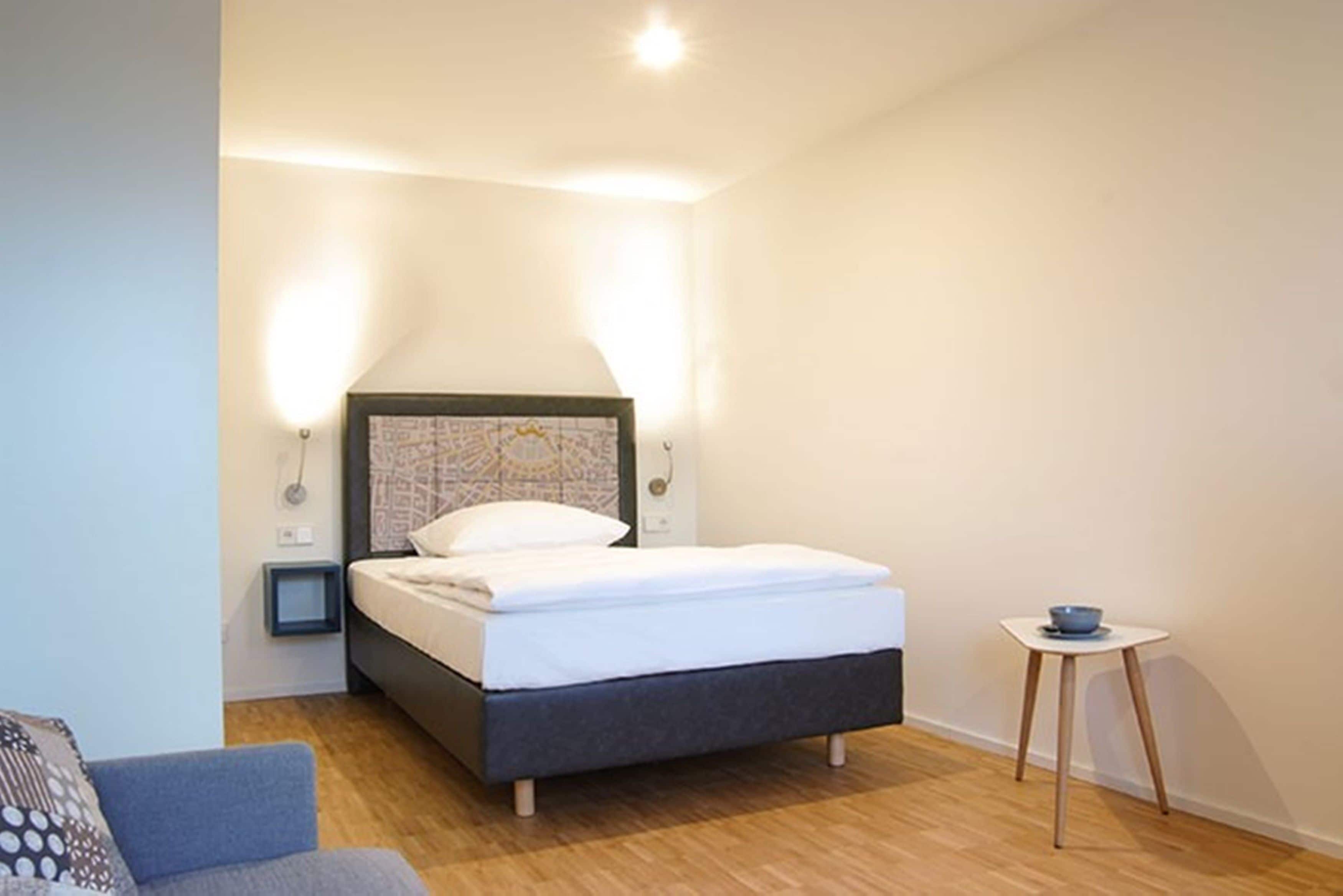 Une chambre à coucher avec un lit, des tables de chevet, une petite table et une chaise.