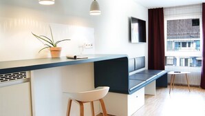 A modern kitchen with a built-in bench, a potted plant, and a small table.