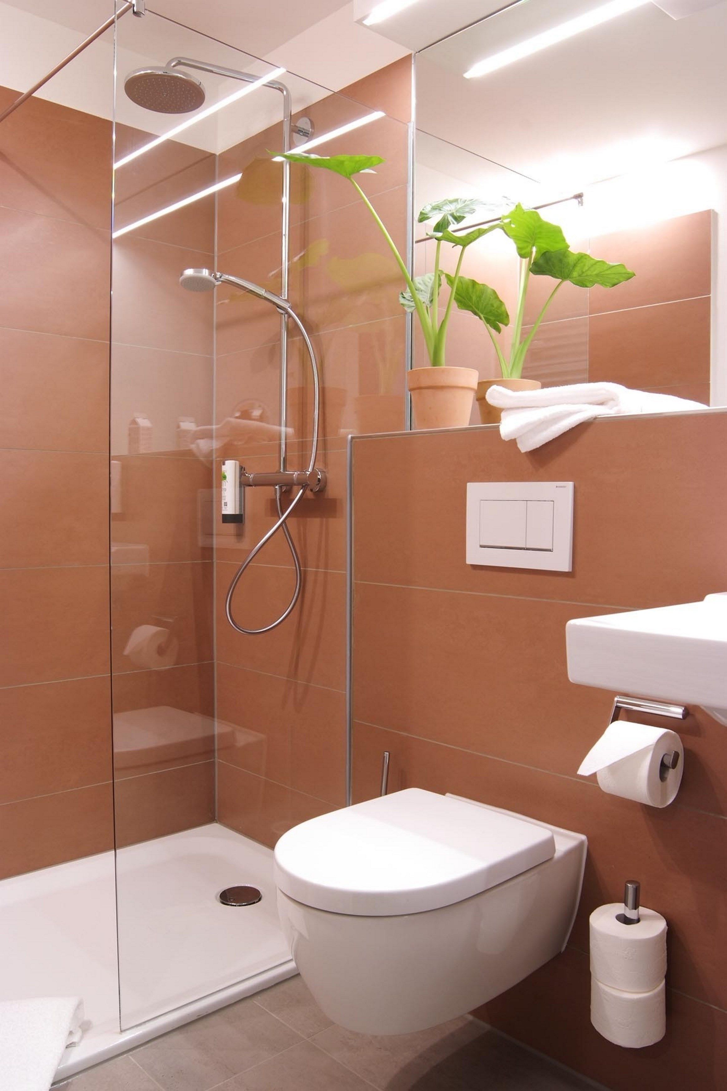 Une salle de bain moderne avec une douche à parois de verre, des toilettes et un lavabo.