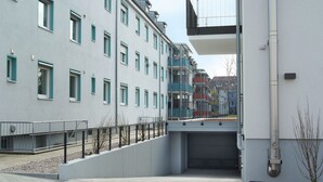 Un edificio moderno con varios balcones y una entrada protegida.