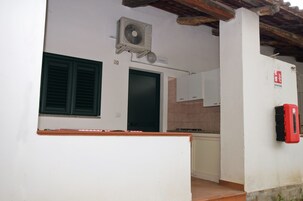 A kitchen with a stove, cabinets, and a red fire extinguisher.