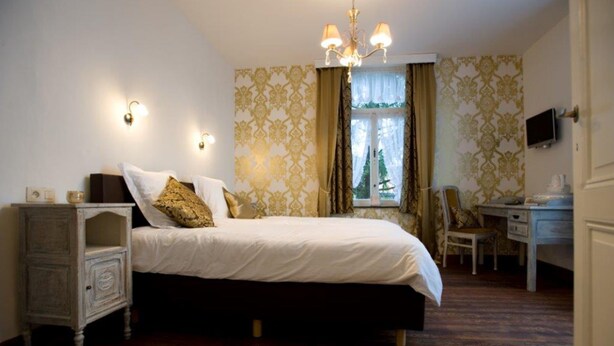 A bedroom with a bed, bedside table, and a desk. - Villa Esperanza (Tongeren)