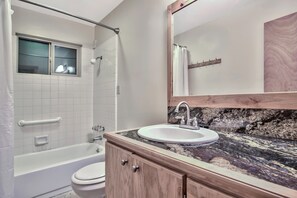 A bathroom with a bathtub, toilet, and sink.