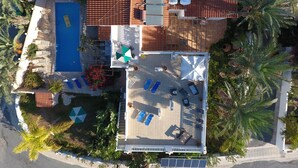 Vista aérea de una propiedad con piscina, zona de estar al aire libre y terraza en la azotea.