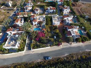 Vista aérea de una zona residencial con casas, piscinas y paneles solares.