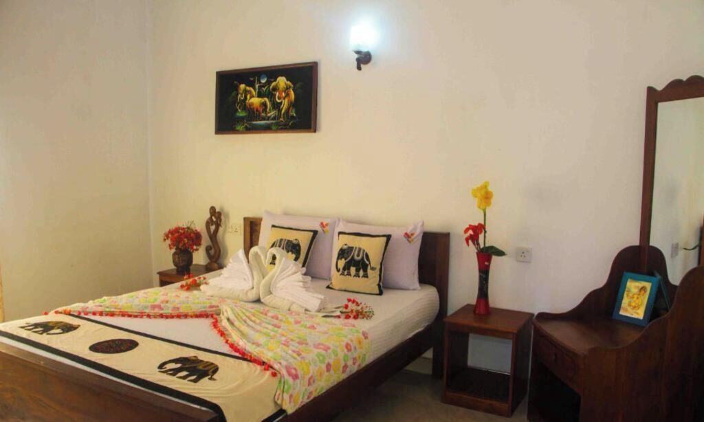 Una habitación de hotel con una cama, una mesita de noche, un espejo y un cuadro colgado en la pared.