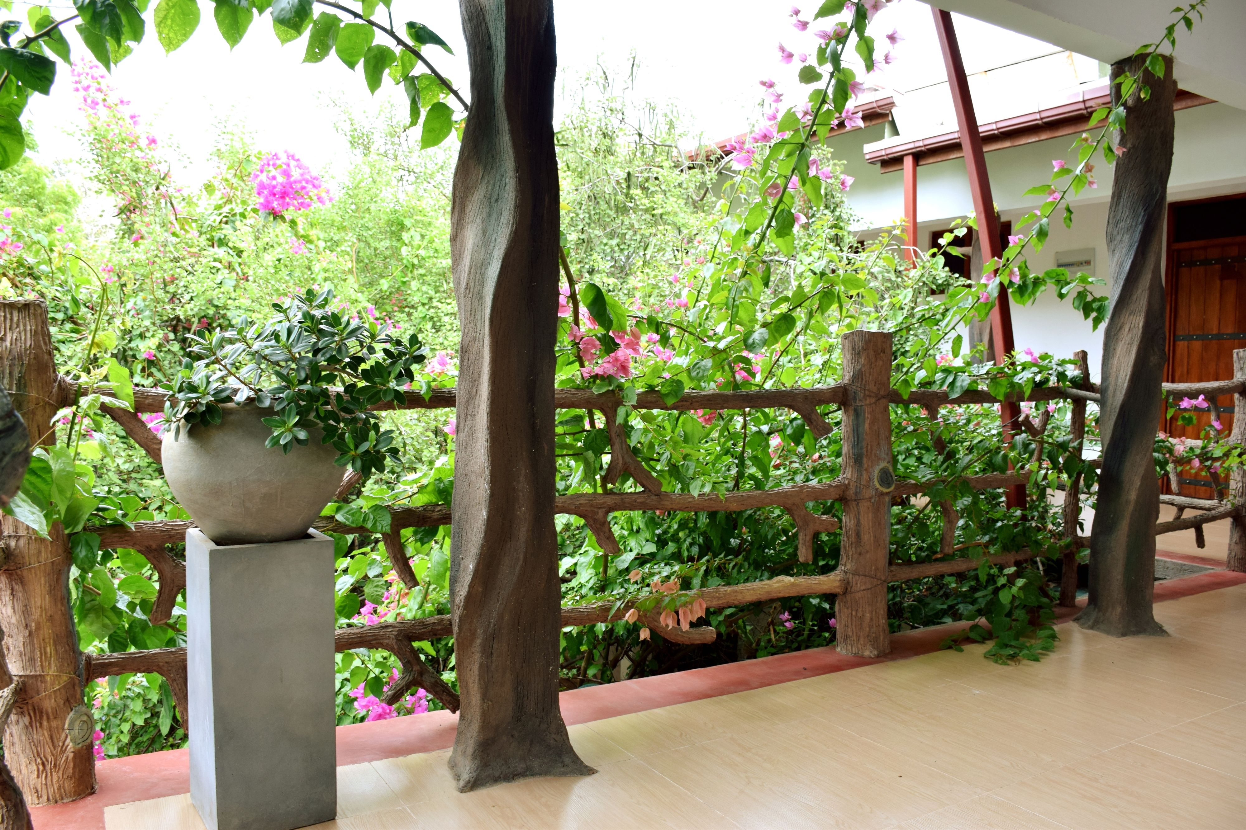 A wooden fence with a planter and a tree in a garden area.