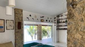 A modern living room with a teal sofa, a beige sofa, and a stone accent wall. - Pousada Serra e Mar (Angra dos Reis)