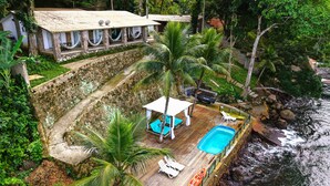A secluded resort with a pool, lounge chairs, and a hammock. - Pousada Serra e Mar (Angra dos Reis)
