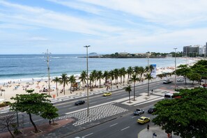 Eine Küstenstadt mit Strand, Palmen und einer belebten Straße.