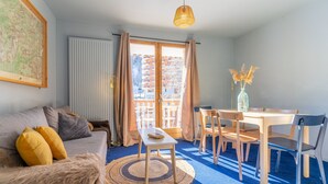 Un salon comprenant un canapé, une table basse et une table à manger avec des chaises.
