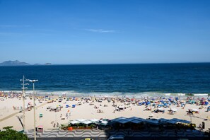 Une plage avec des parasols et des gens.