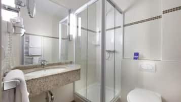 A modern bathroom with a glass shower enclosure, a sink with a towel rack, and a toilet.
