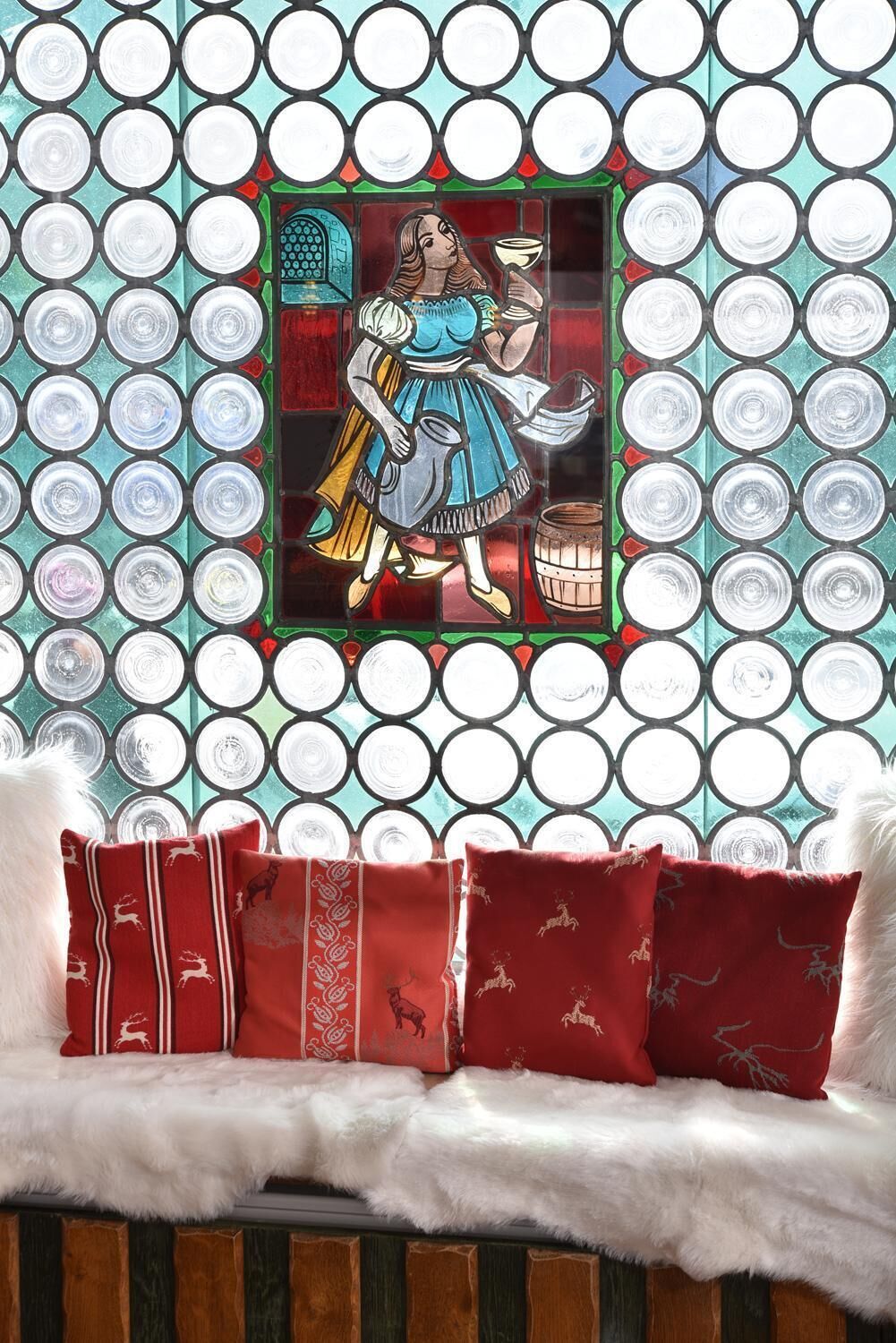 A room with a patterned wall and a window with a stained glass design.