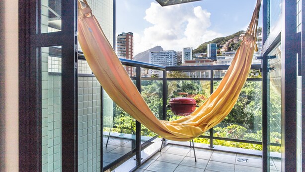 Un hamac sur un balcon avec vue sur la ville.