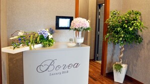 A reception desk with a sign reading "Borea Luxury B&B" and a potted plant to the right. - Borea Luxury B&B (Pescara)