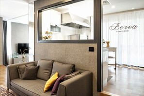 Habitación Deluxe | Área de sala de estar | Televisión de pantalla plana 