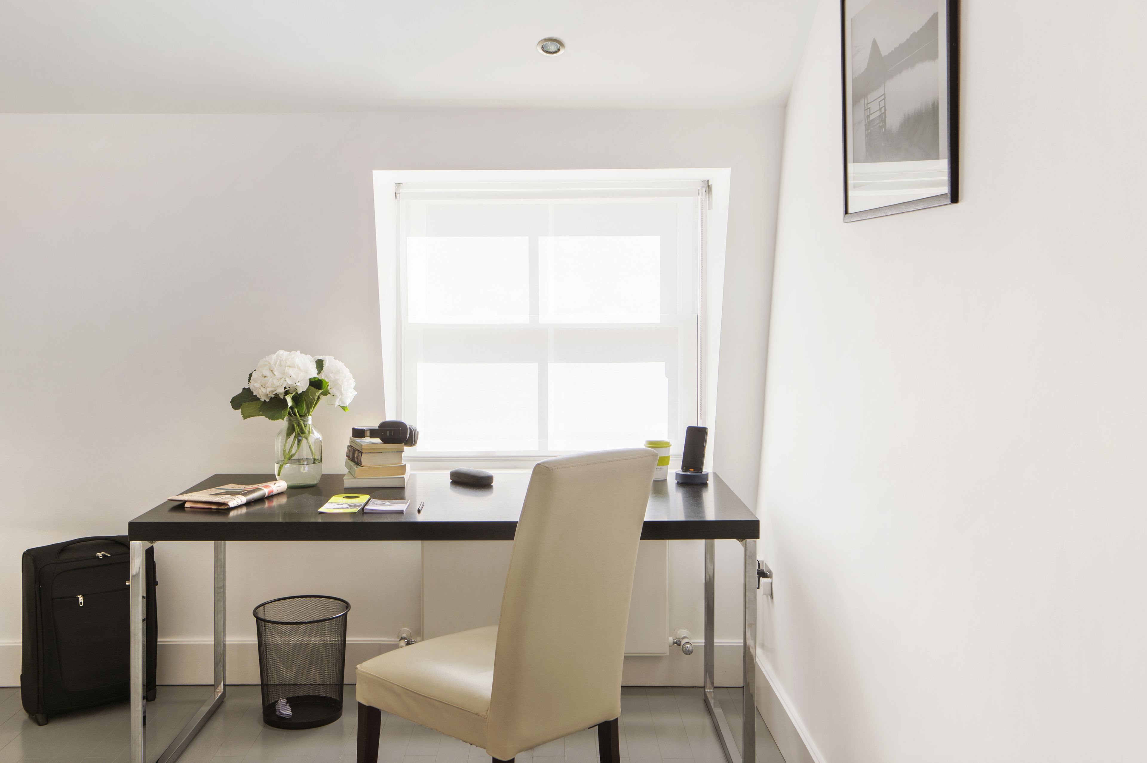 A small, modern office space with a desk, chair, and a window.