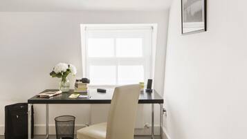 A small, modern office space with a desk, chair, and a window.