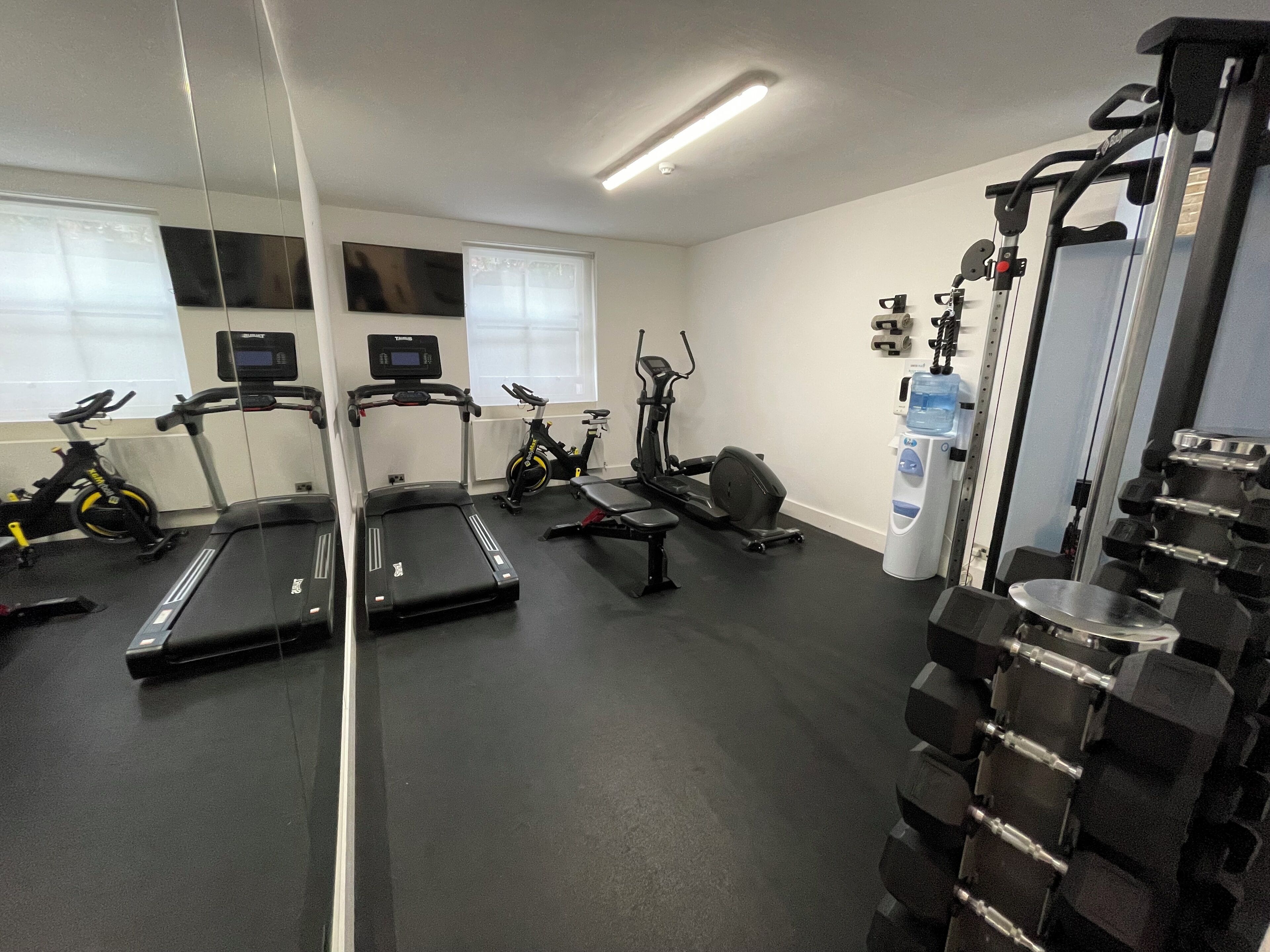 A gym with treadmills, stationary bikes, and weightlifting equipment.