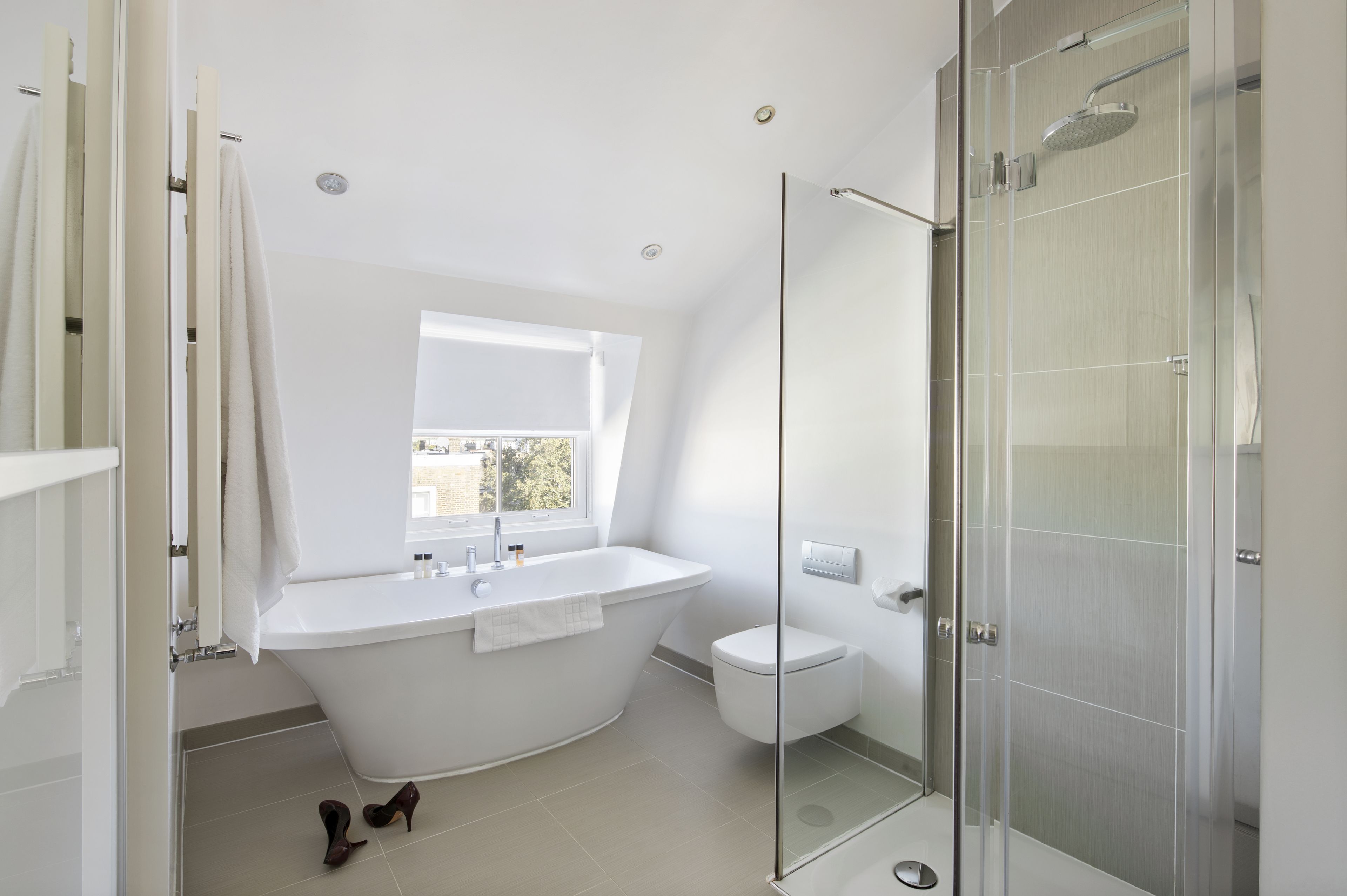 A modern bathroom with a freestanding bathtub, a glass-enclosed shower, and a toilet.