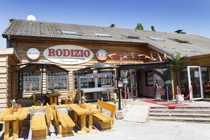 A wooden building with a sign reading "RODIZIO" and "Churrasquería".