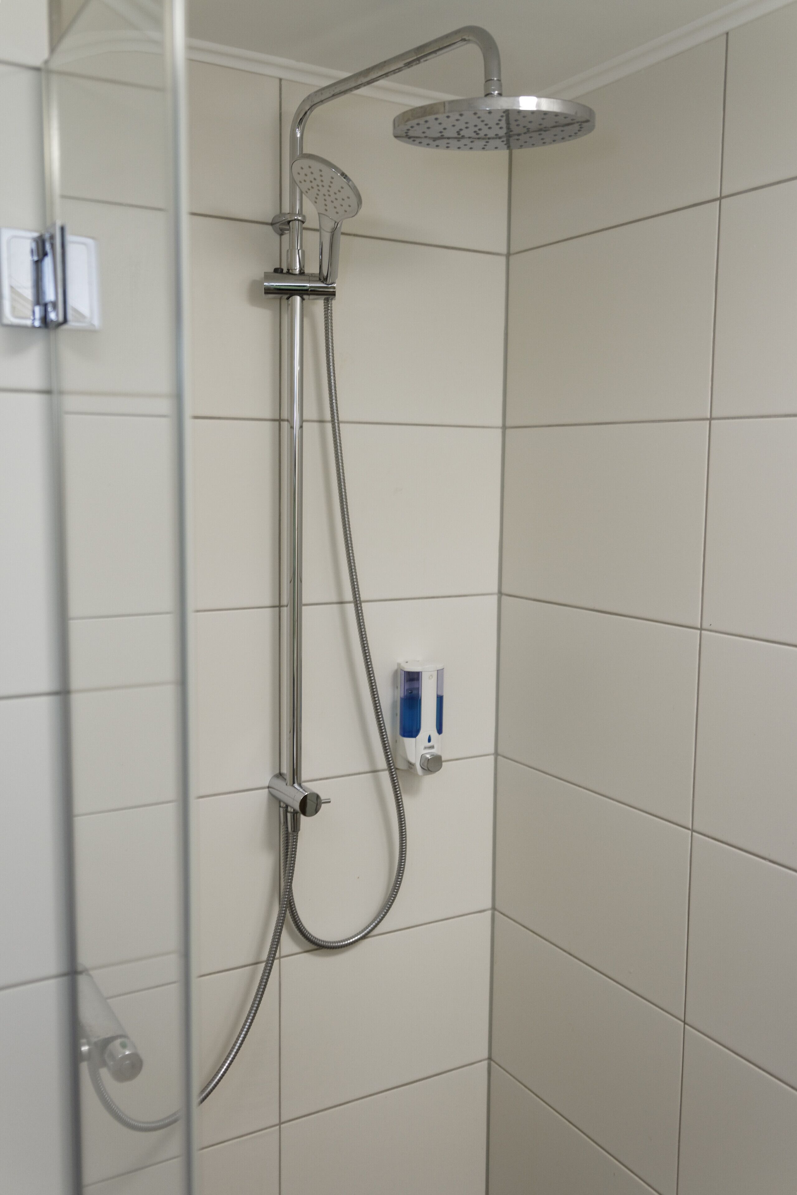 Ducha con cabezal de ducha de mano y grifo empotrado.