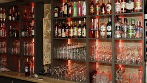 A bar area with shelves of liquor bottles and a variety of glasses. - Hotel Restaurant Rodizio Paderborn (Altenbeken)