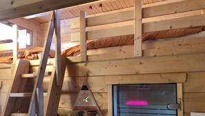 A wooden interior with a loft bed, a ladder, a clock, and a coffee machine. - Hotel Restaurant Rodizio Paderborn (Altenbeken)