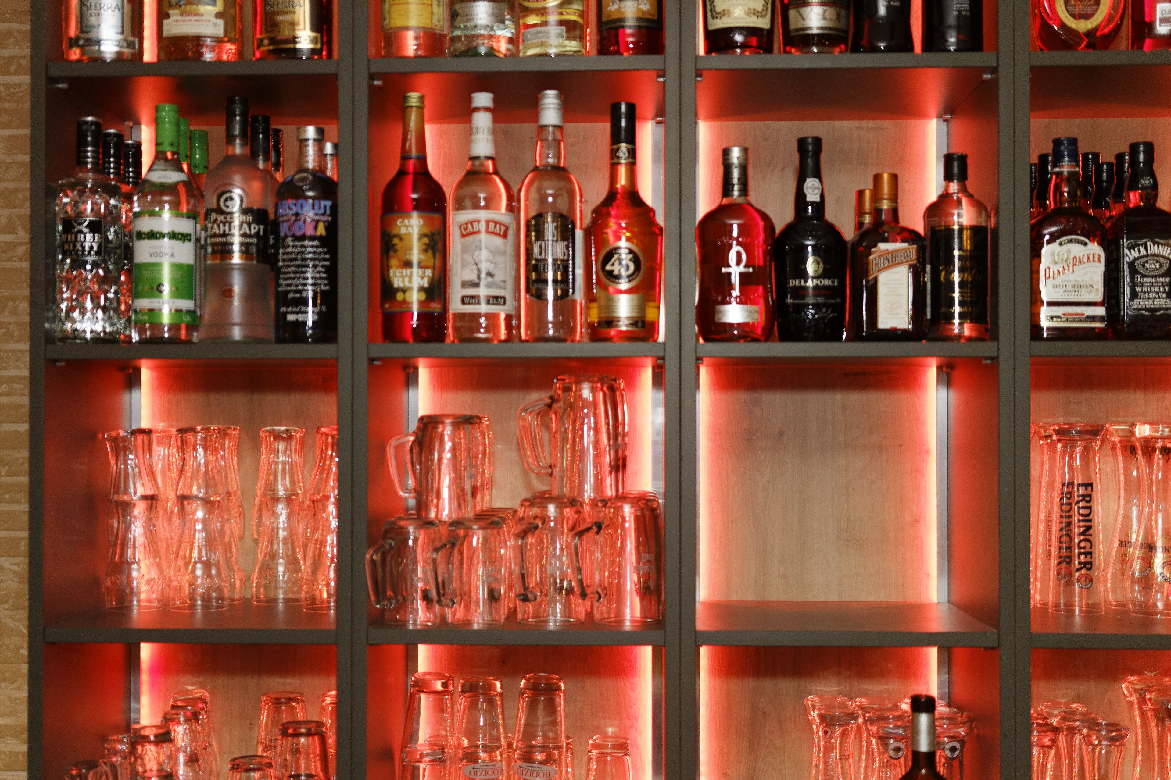 A bar area with shelves of liquor bottles and glassware.