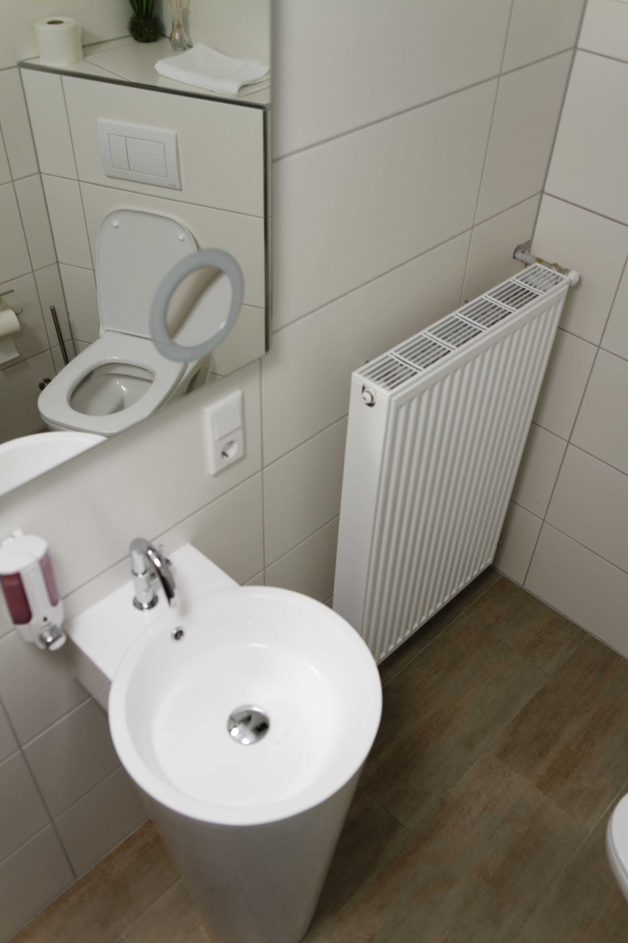 Un baño con inodoro, lavamanos y radiador.