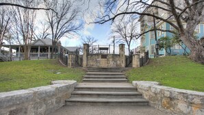 A set of stone steps leading up to a stone wall with a metal railing. - Inn on the Riverwalk (San Antonio)