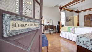 A bedroom with a four-poster bed, a desk, and a chair. - Inn on the Riverwalk (San Antonio)