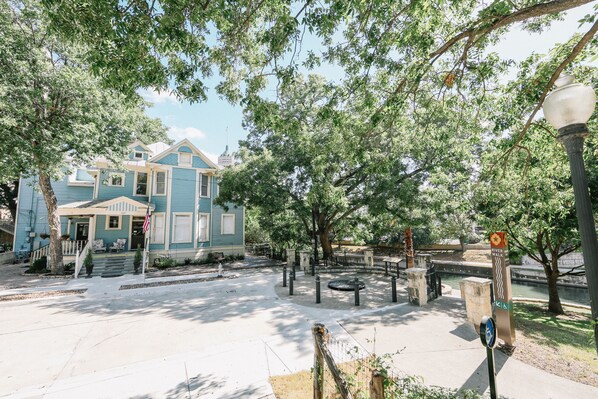 A residential area with a blue house, a sidewalk, trees, and a street lamp. - Inn on the Riverwalk (San Antonio)