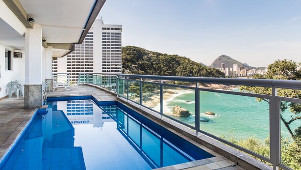 Piscina com vista para a praia e montanhas.