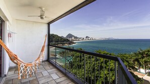 A balcony with a hammock, offering a view of the ocean and cityscape. - Omar do Rio - Apartamento V210 (Rio de Janeiro)
