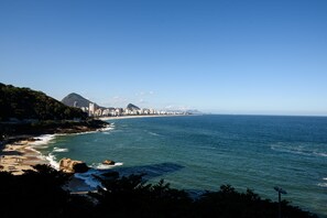 Un paisaje costero con una montaña destacada, playa y océano.