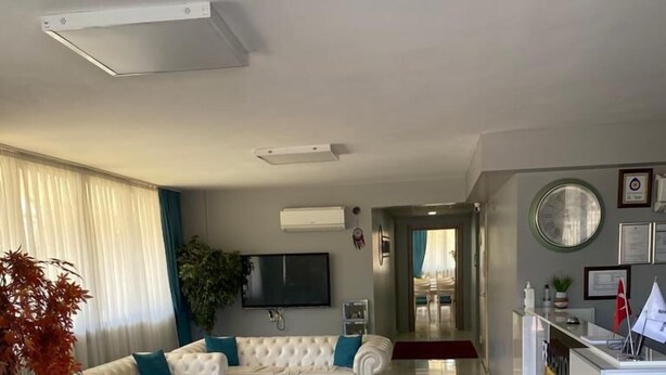 Una sala moderna con un conjunto de sofás, una zona de comedor y una cocina.