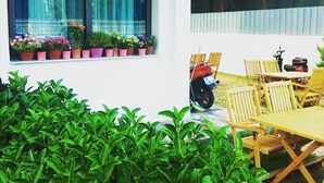Un patio con una mesa, sillas, una motocicleta y macetas.