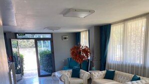 Una sala de estar moderna con dos sofás de cuero blanco, una alfombra roja y una mesa de centro.